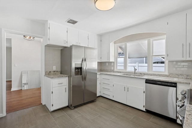 kitchen with white cabinetry, tasteful backsplash, and appliances with stainless steel finishes