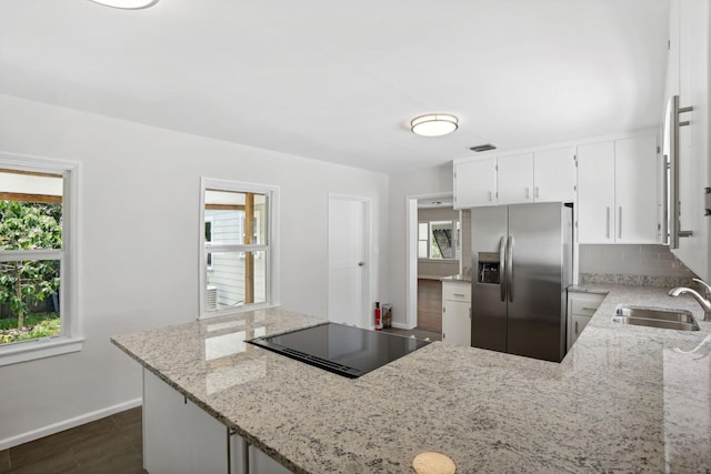 kitchen featuring stainless steel fridge, sink, and a wealth of natural light