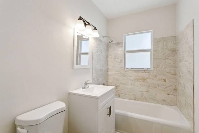 full bathroom featuring vanity, tiled shower / bath, and toilet