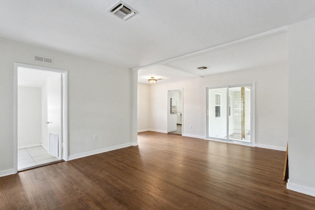 spare room featuring dark wood-type flooring