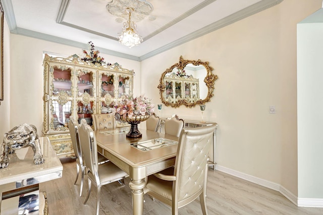 dining area featuring a chandelier, light hardwood / wood-style floors, and ornamental molding