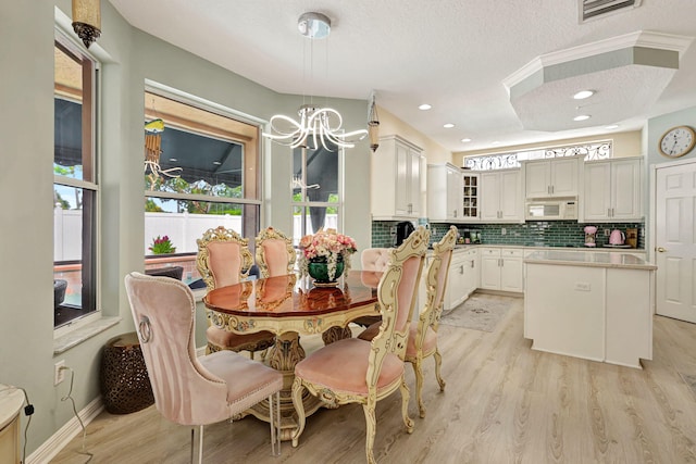 dining room featuring a notable chandelier, a textured ceiling, and light hardwood / wood-style flooring