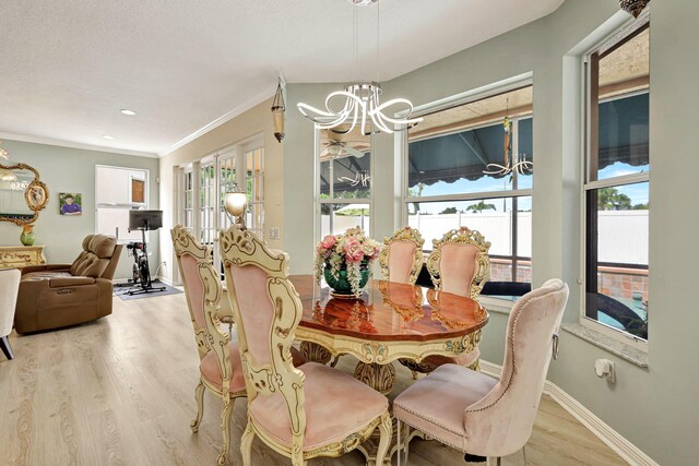 dining space with a chandelier, light wood-type flooring, plenty of natural light, and ornamental molding