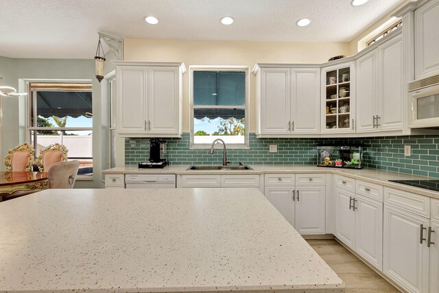 kitchen featuring white cabinetry, sink, a healthy amount of sunlight, and white appliances