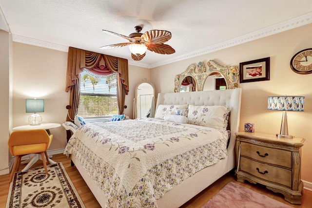 bedroom with ceiling fan, wood-type flooring, a textured ceiling, and ornamental molding