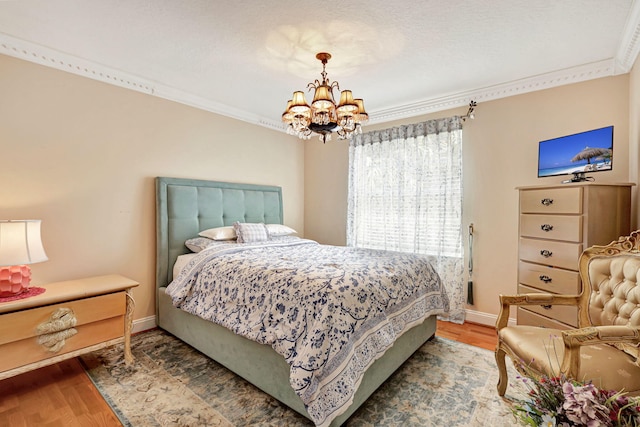 bedroom featuring crown molding, wood-type flooring, and an inviting chandelier