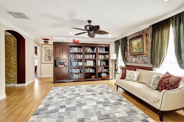 sitting room featuring ceiling fan, wood-type flooring, and ornamental molding