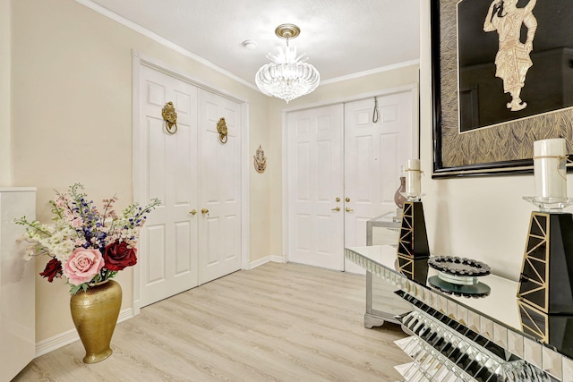 entryway featuring wood-type flooring, crown molding, and an inviting chandelier