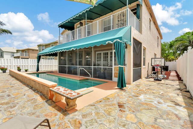 view of swimming pool featuring a patio and a sunroom