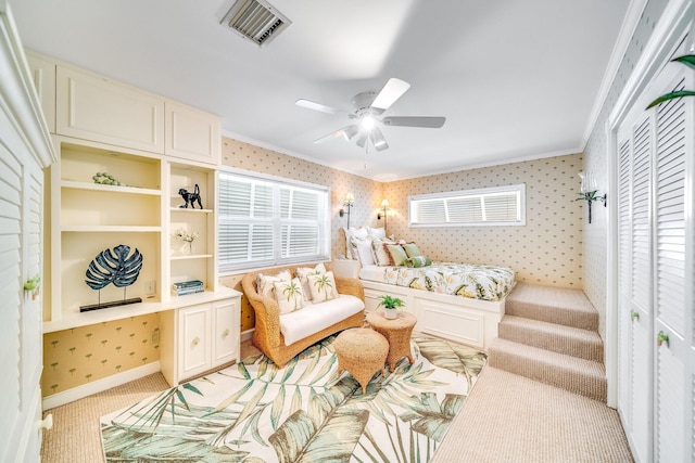 sitting room featuring ceiling fan, light colored carpet, and crown molding