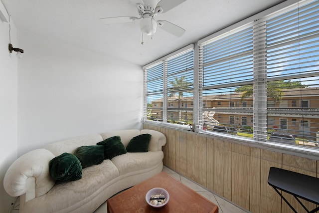 interior space featuring ceiling fan, wooden walls, and light tile patterned floors