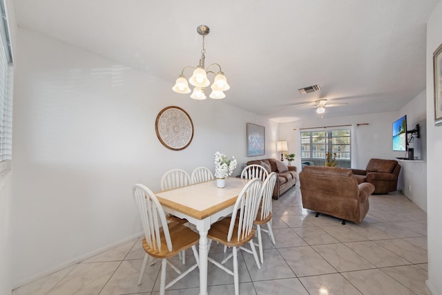 dining space with ceiling fan with notable chandelier and light tile patterned floors