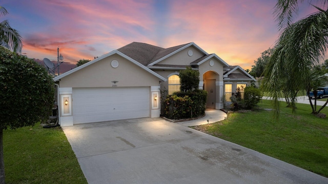 view of front of home with a garage and a lawn