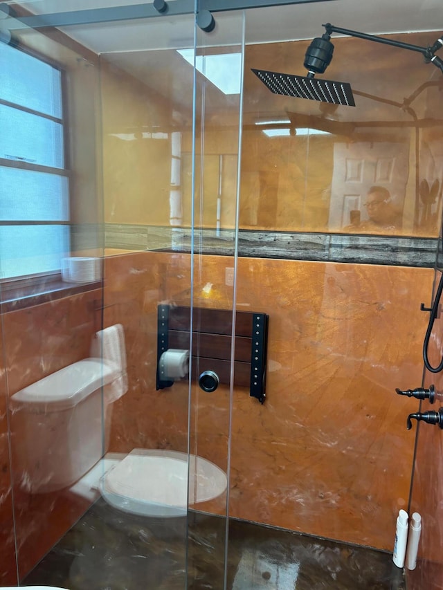 bathroom featuring tile walls, toilet, and a tile shower