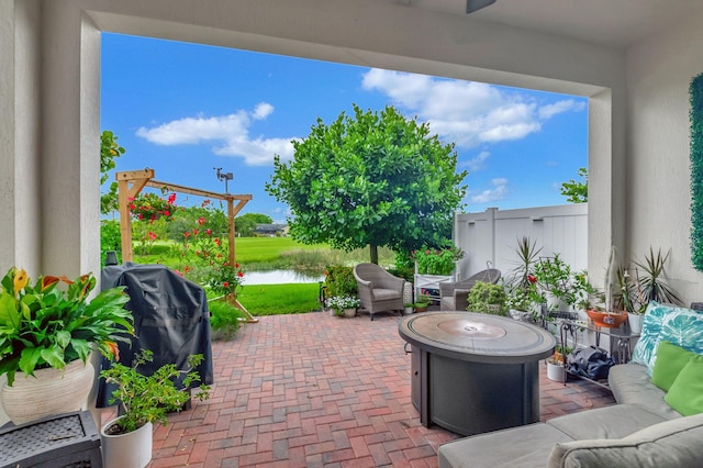 view of patio with grilling area and a water view