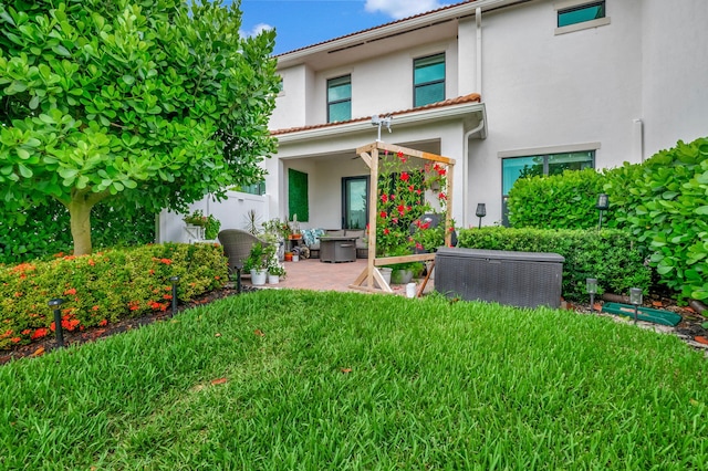 back of property with a patio and a lawn