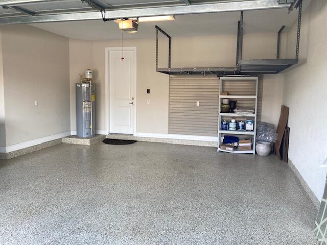 garage featuring a garage door opener and water heater