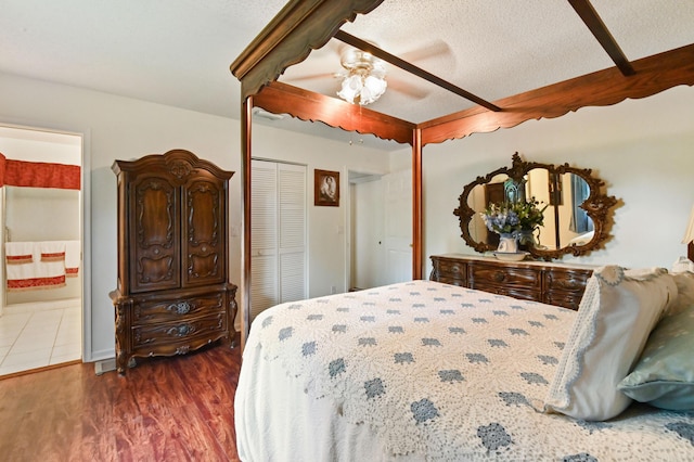 bedroom featuring ceiling fan, dark wood-type flooring, connected bathroom, and a textured ceiling