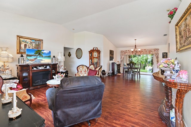 living room featuring an inviting chandelier, lofted ceiling, and dark hardwood / wood-style floors