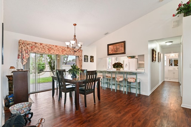 dining area featuring dark wood-type flooring, a notable chandelier, and vaulted ceiling