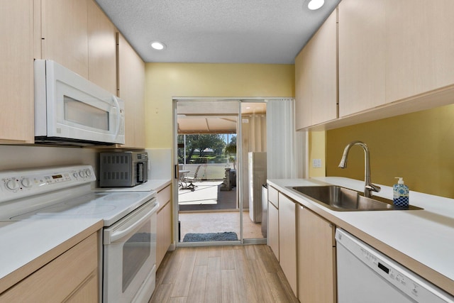 1217 NW Sun Terrace Cir Unit B, Port Saint Lucie, FL 34986 - kitchen featuring white appliances, a sink, light wood-style floors, light countertops, and a textured ceiling