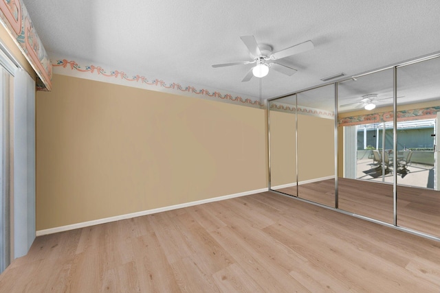 unfurnished bedroom featuring ceiling fan, light hardwood / wood-style floors, a textured ceiling, and a closet