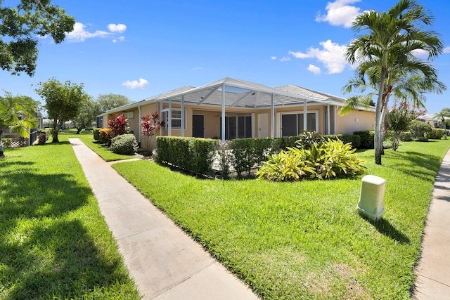 view of front of home with a front yard and glass enclosure