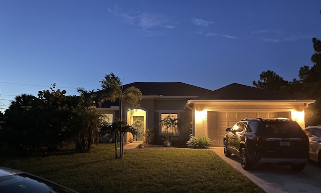 ranch-style home with a yard and a garage