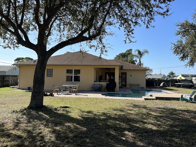 rear view of property with a lawn, a patio, a fenced in pool, and a trampoline