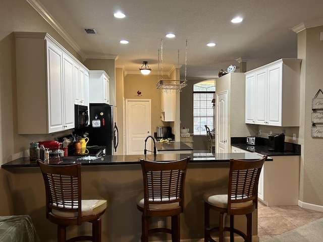 kitchen featuring kitchen peninsula, white cabinetry, light tile patterned floors, and black appliances