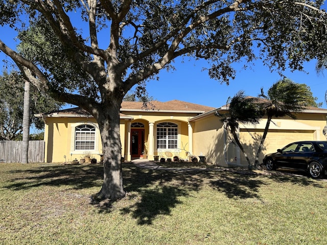 ranch-style home featuring a garage and a front lawn