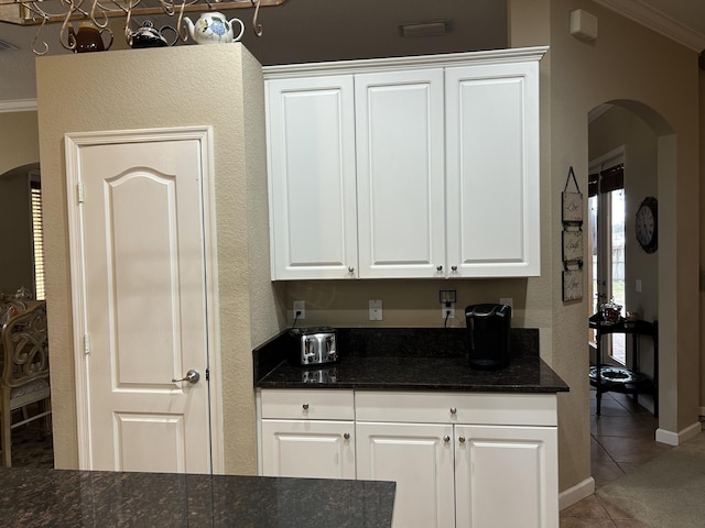 kitchen featuring white cabinets, tile patterned floors, and ornamental molding