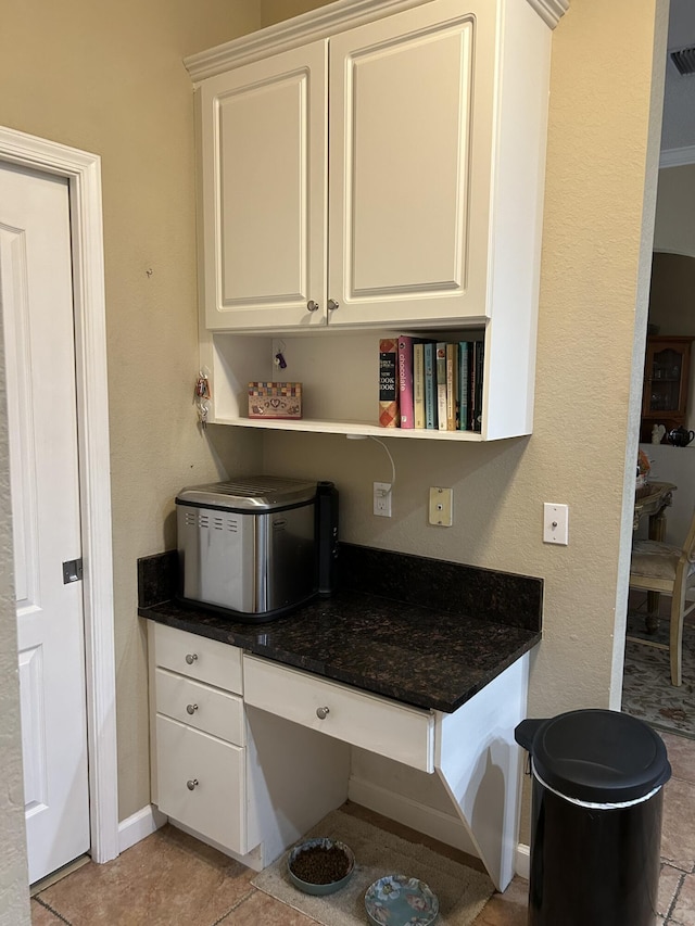 kitchen with white cabinetry and light tile patterned flooring