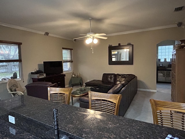 living room with ceiling fan, light colored carpet, and ornamental molding