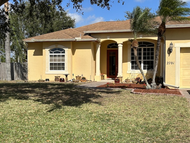 view of front of home with a front yard and a garage