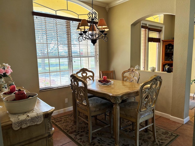 tiled dining area featuring an inviting chandelier and ornamental molding