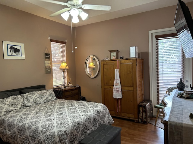 bedroom with dark hardwood / wood-style flooring and ceiling fan