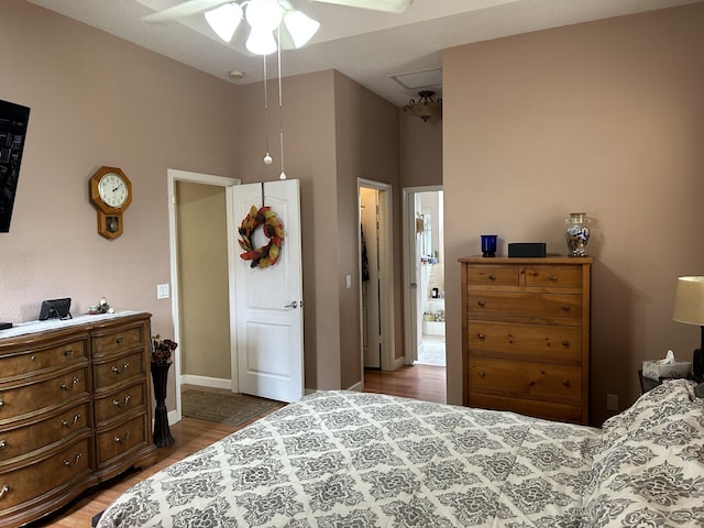 bedroom featuring ceiling fan, hardwood / wood-style floors, and a towering ceiling