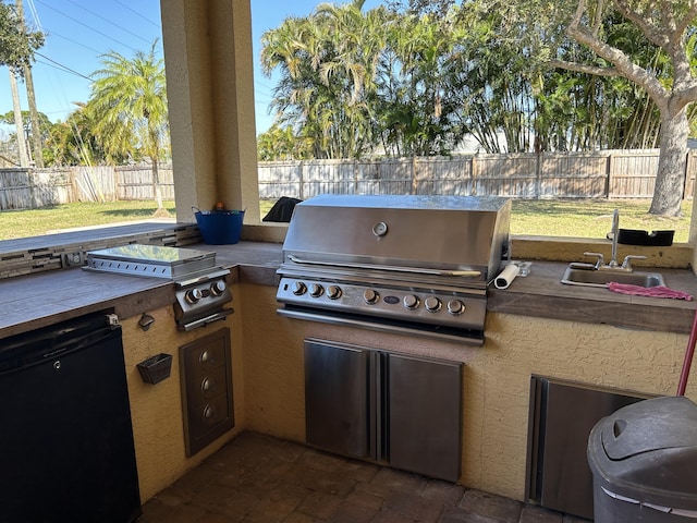 view of patio / terrace featuring an outdoor kitchen, sink, and grilling area