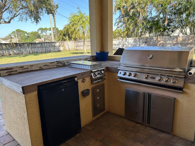 view of patio with area for grilling and a grill