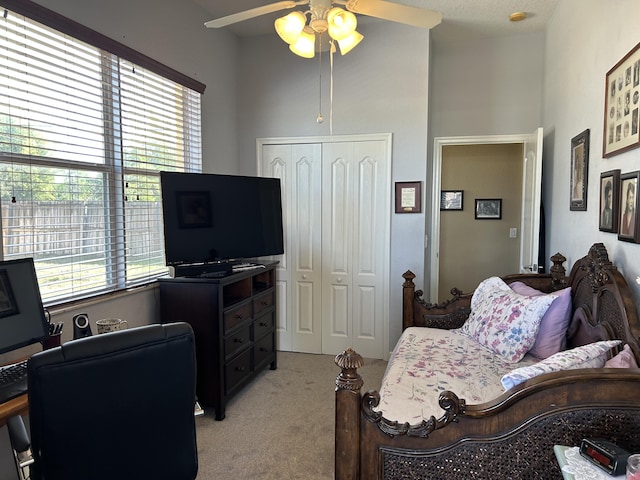 office space with ceiling fan, light carpet, a wealth of natural light, and a high ceiling