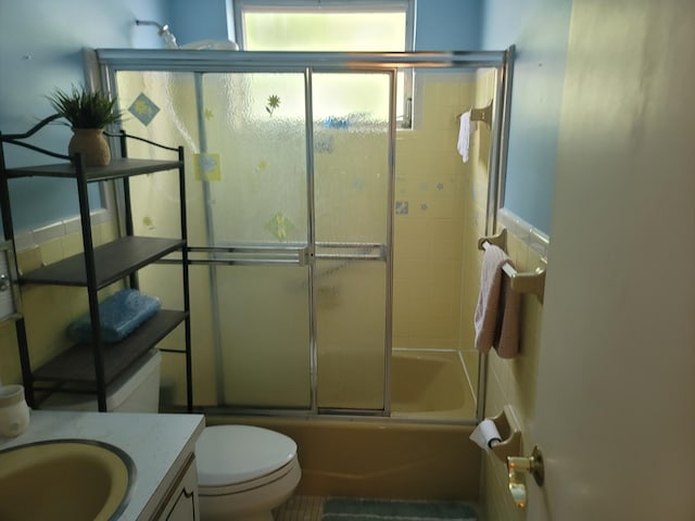 full bathroom with vanity, shower / bath combination with glass door, and toilet