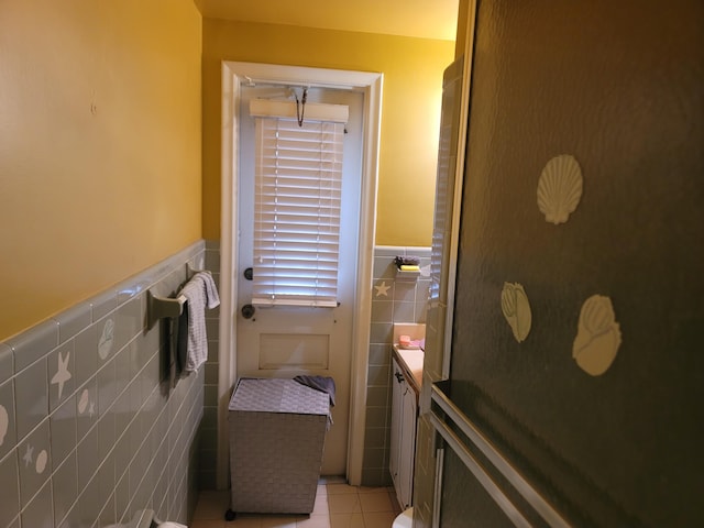 bathroom with tile patterned flooring, tile walls, and vanity