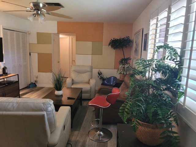 living room featuring ceiling fan and hardwood / wood-style flooring