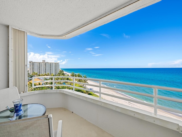 balcony with a water view and a beach view