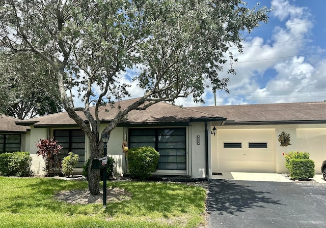 single story home with a garage and a front lawn