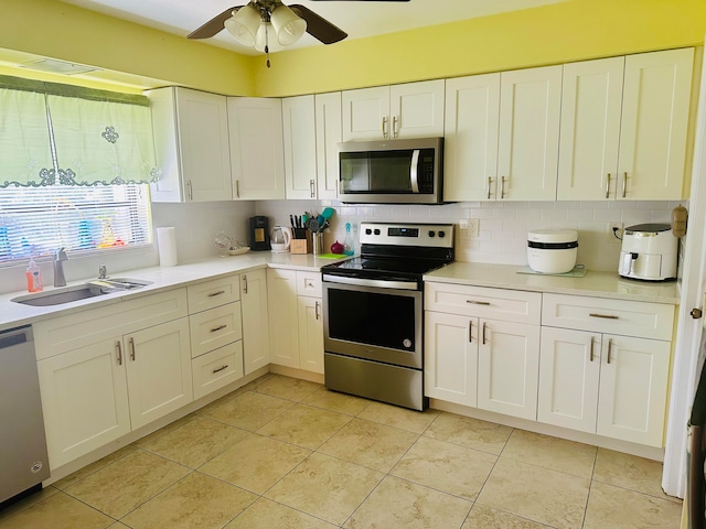 kitchen featuring white cabinetry, tasteful backsplash, ceiling fan, stainless steel appliances, and sink