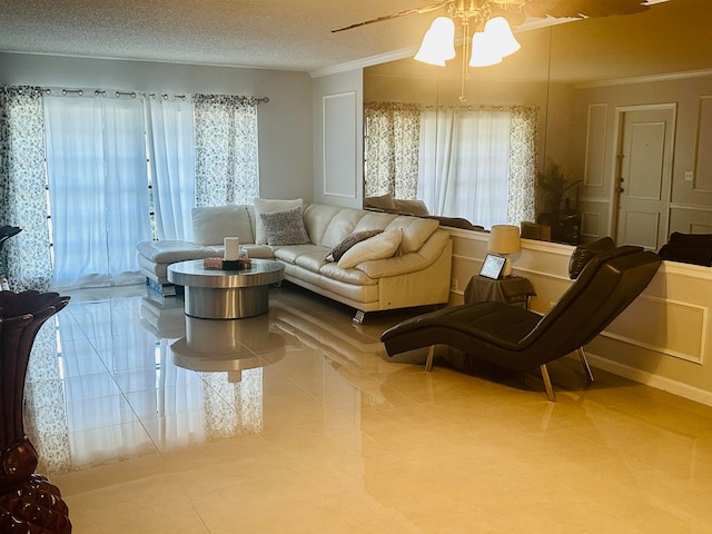 living room with a textured ceiling, a wealth of natural light, light tile patterned floors, and ceiling fan