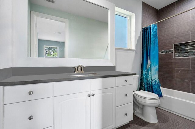 full bathroom featuring shower / bath combination with curtain, vanity, and toilet