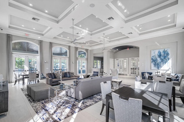 tiled living room with ceiling fan, french doors, coffered ceiling, and ornamental molding